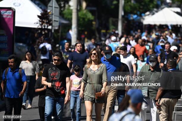 People walk down a street during the presidential and legislative elections in San Salvador on February 4, 2024. Polls opened in El Salvador Sunday...