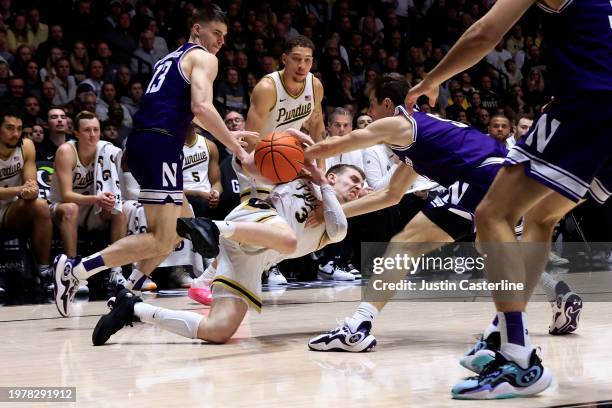 Braden Smith of the Purdue Boilermakers and Ryan Langborg of the Northwestern Wildcats battle for the ball at Mackey Arena on January 31, 2024 in...