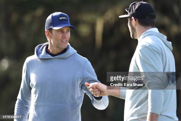 Former NFL quarterback Tom Brady, left, and Josh Allen of the NFL Buffalo Bills bump fists with during the first round of the AT&T Pebble Beach...