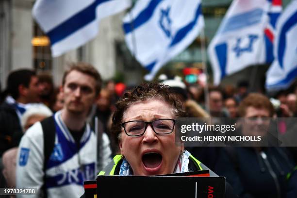 Protesters hold placards and wave Israeli flags as they take part in a demonstration "Rape is NOT resistance" outside the BBC headquarters, in...
