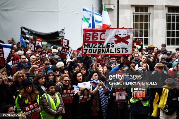 Protesters hold placards and wave Israeli flags as they take part in a demonstration "Rape is NOT resistance" outside the BBC headquarters, in...