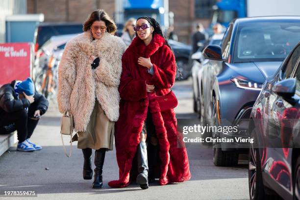 Michelle Fleur wears beige faux fur coat, skirt, bag, black boots & sunglasses & Amaka Hamelijnck wears red red coat, Prada bag, hair band, black...
