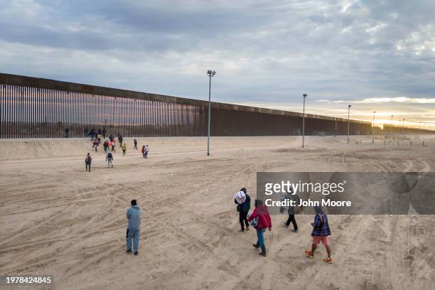 Seen from an aerial view, immigrants walk towards the U.S.-Mexico border wall after crossing the Rio Grande into El Paso, Texas on February 01, 2024...