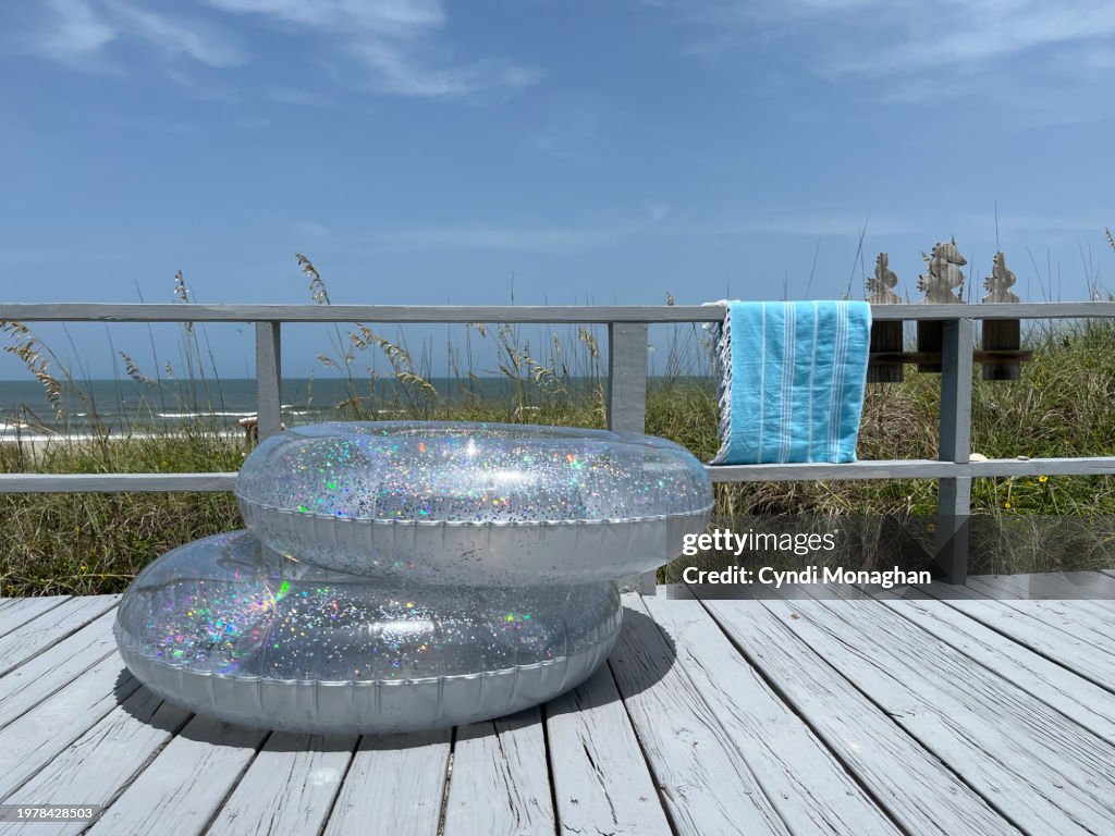 Glitter swim inner tubes stacked on a beach cottage porch