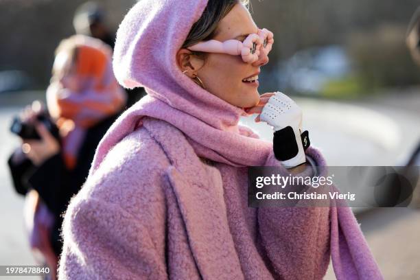 Guest wears pink coat, scarf, jumper, sunglasses, Chanel gloves outside Marimekko during the Copenhagen Fashion Week AW24 on February 01, 2024 in...