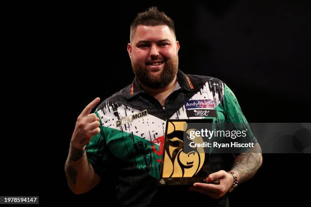 Michael Smith of England celebrates victory with the Trophy after defeating Gerwyn Price of Wales during the Final match between Michael Smith of...