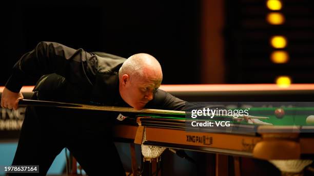 John Higgins of Scotland plays a shot in the fourth round match against Mark Allen of Northern Ireland on day four of 2024 BetVictor German Masters...