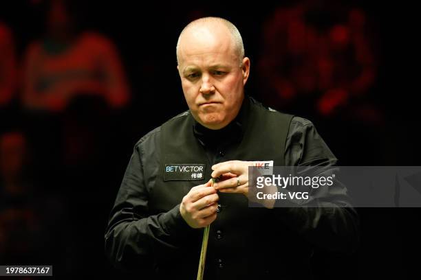 John Higgins of Scotland chalks the cue in the fourth round match against Mark Allen of Northern Ireland on day four of 2024 BetVictor German Masters...