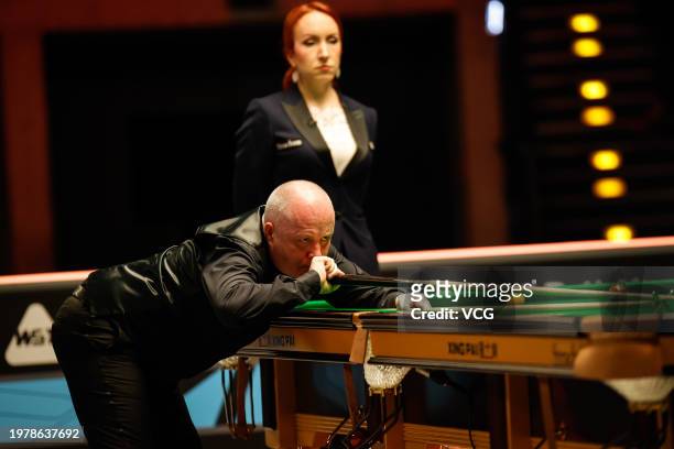 John Higgins of Scotland plays a shot in the fourth round match against Mark Allen of Northern Ireland on day four of 2024 BetVictor German Masters...