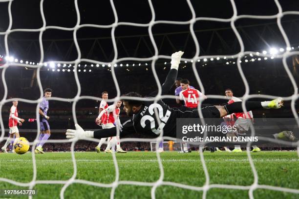 Arsenal's Spanish goalkeeper David Raya dives to stop the ball from entering the goal during the English Premier League football match between...