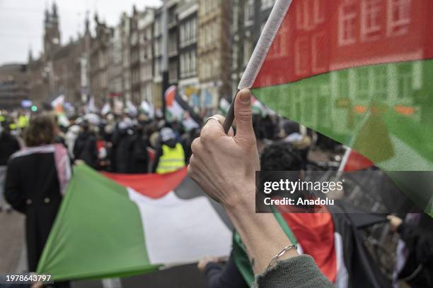 People, carrying Palestinian flags and banners, gather at Dam Square to stage a solidarity demonstration with Palestinians and protest against the...