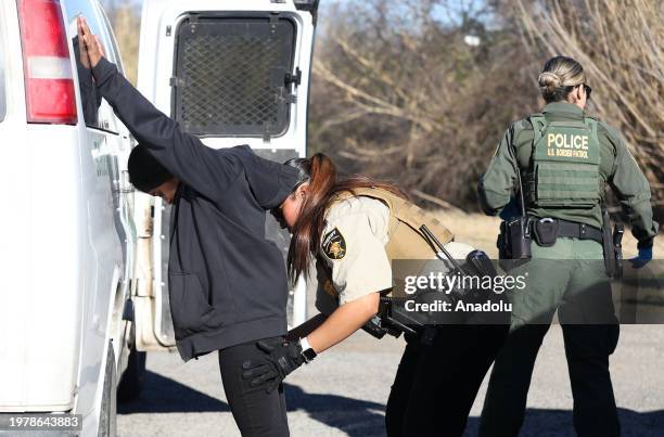 Maverick County Sheriff searches an migrant as a group of migrants from different nationalities arrive at the Mexico-US border despite heightened...