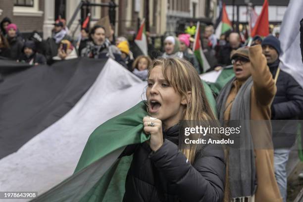 People, carrying Palestinian flags and banners, gather at Dam Square to stage a solidarity demonstration with Palestinians and protest against the...