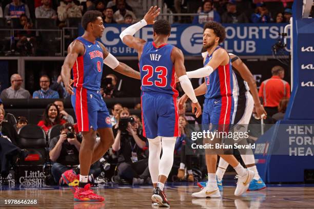 Jalen Duren of the Detroit Pistons high fives Cade Cunningham and Jaden Ivey during the game against the Orlando Magic on February 4, 2024 at Little...