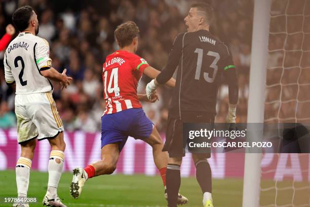 Atletico Madrid's Spanish midfielder Marcos Llorente scores the equalizing goal during the Spanish league football match between Real Madrid CF and...