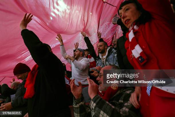 Arsenal fans beneath a giant flag during the Premier League match between Arsenal FC and Liverpool FC at Emirates Stadium on February 4, 2024 in...
