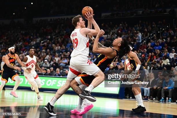 Jaylin Williams of the Oklahoma City Thunder takes a charge from Jakob Poeltl of the Toronto Raptors in the first half at Paycom Center on February...