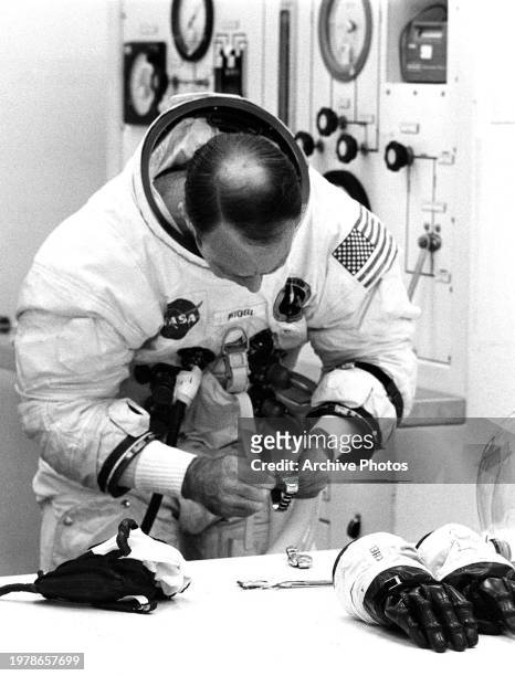 Astronaut Edgar 'Ed' Mitchell, lunar module pilot for the Apollo 14 mission adjusts his Rolex watch while he suits up at the Kennedy Space Center's...