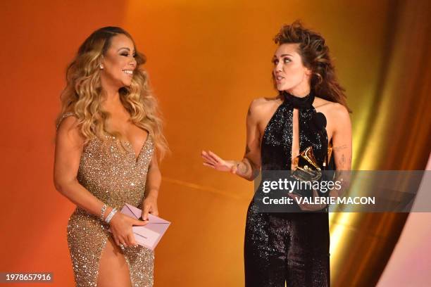 Singer-songwriter Miley Cyrus accepts the Best Pop Solo Performance award for "Flowers" from US singer-songwriter Mariah Carey on stage during the...