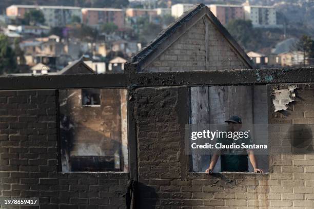 Man observes his house destroyed by fires in El Olivar on February 4, 2024 in Vina del Mar, Chile. President Gabriel Boric declared state of...