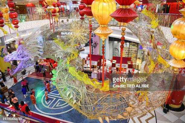 People gather next to a 500-foot-long dragon installation displayed at a mall in the Chinatown district of Manila on February 5 ahead of the Lunar...