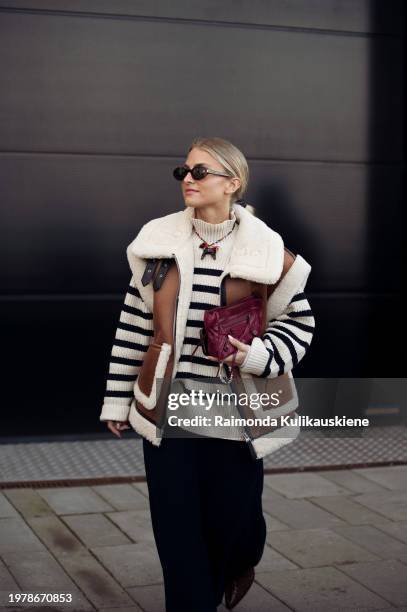 Olivia Anna-Catharina T. Wears a long black skirt, black and white striped top, brown and white leather vest, and burgundy bag outside Munthe during...