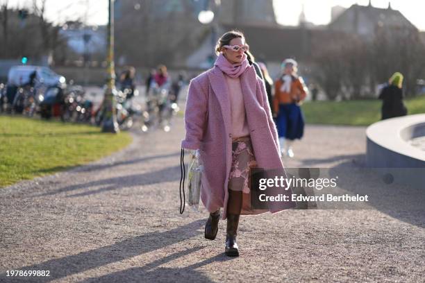 Guest wears a pink full outfit, sunglasses, a fluffy long oversized blazer jacket , a pullover leather boots , outside Marimekko, during the...