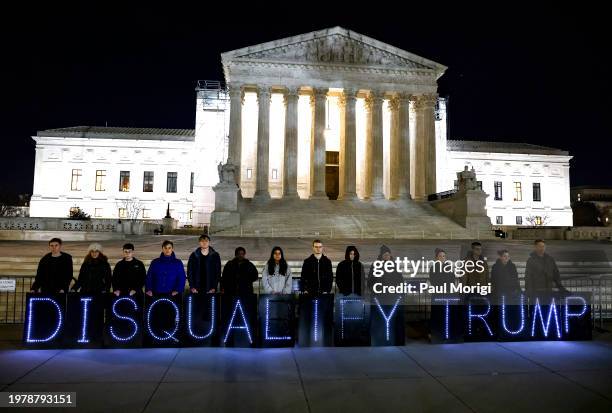 MoveOn members hold signs that read "Disqualify Trump" during a rally outside of the U.S. Supreme Court of the United States on February 01, 2024 in...