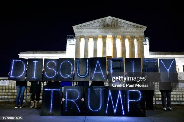 MoveOn members hold signs that read "Disqualify Trump" during a rally outside of the U.S. Supreme Court of the United States on February 01, 2024 in...