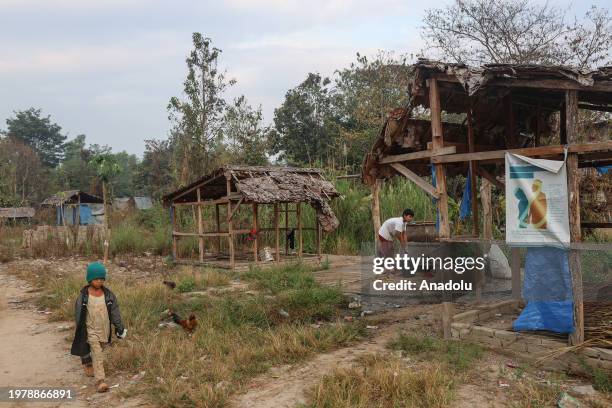 Young boy washes clothes in a bucket in Laukaw Internally Displaced People camp in Karen State, Myanmar. The camp, established after a Myanmar...