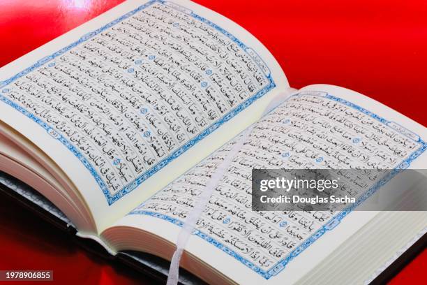 muslim book in arab language on a red background - islamismo sunita imagens e fotografias de stock