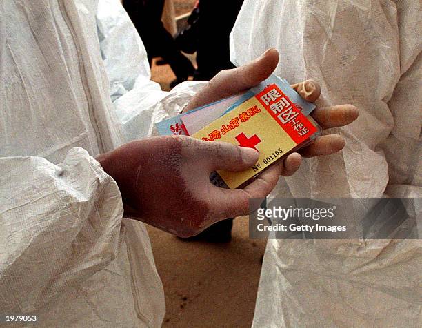 Health worker holds passes needed to gain access to the restricted area of the Xiaotangshan hospital that's for medics and patients only and which is...