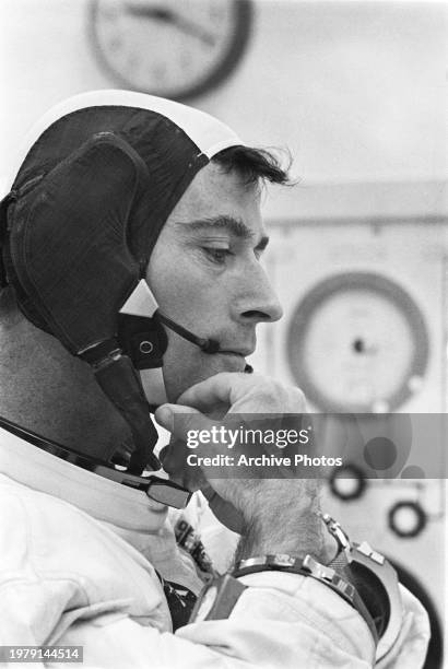 Astronaut and Apollo 10 command module pilot John W. Youngadjusts strap on his communications cap while suiting up for the lunar orbit mission on May...