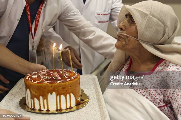 Year-old Hatice Duzer, who was rescued from under the rubble in the earthquakes on Feb. 6 being discharged with a cake after receiving treatment in...