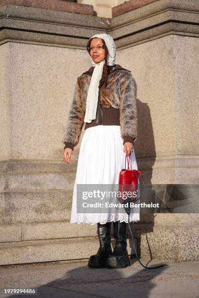 Guest wears a white wool scarf over the head, a brown fluffy faux fur coat, a white midi floral embroidery gathered / pleated skirt , black leather...