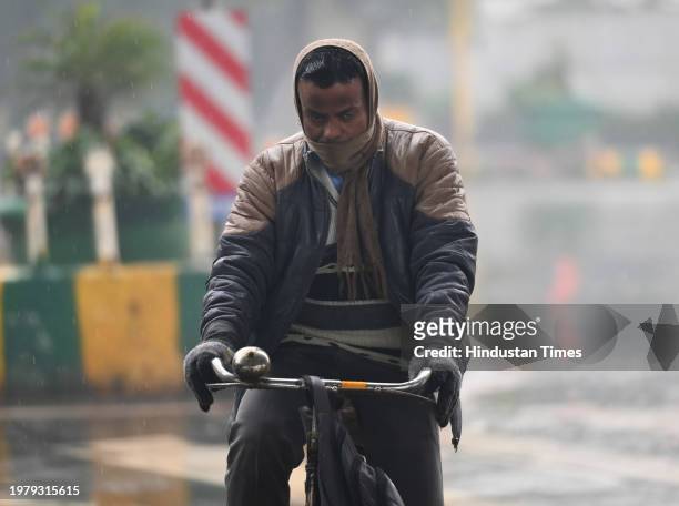 Commuters seen out during light rains at Sector 31-25 road, on February 3, 2024 in Noida, India.