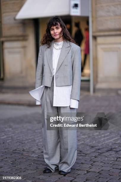 Guest wears a white striped oversized shirt, a gray oversized blazer jacket , suit flared pants , black leather shoes, outside Mark Kenly Domino Tan,...