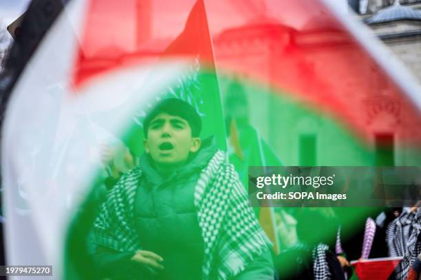 Child stands behind a Palestinian flag during a protest against the Israeli attacks on Palestine. The Humanitarian Relief Foundation IHH organized a...