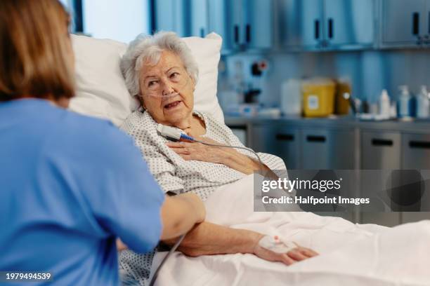 senior patient feeling pain on chest, heart attack symptoms for elderly woman. nurse checking on senior woman in emergency room. healthcare and emotional support for elderly patient. - infarction stock pictures, royalty-free photos & images