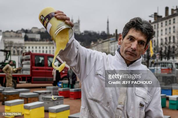 Beekeeper throws royal jelly, as beekeepers gather at Place Bellecour during a de monstration in Lyon, central France, on February 5 to alarm people...