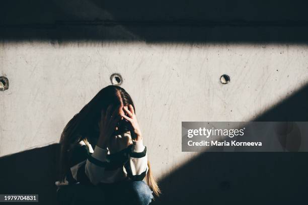 sad woman sits alone in the city. - trastorno causado por estrés postraumático fotografías e imágenes de stock