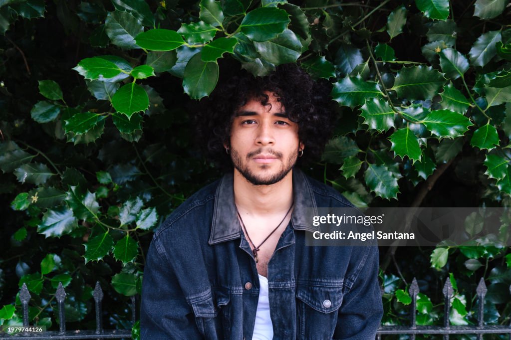 Young Man Smiling Against Leafy Background