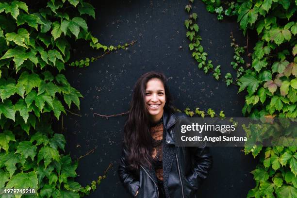 smiling woman against ivy-covered wall - collection launch street style stock pictures, royalty-free photos & images