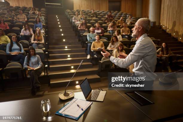 mature professor talking on a class at lecture hall. - poly stock pictures, royalty-free photos & images