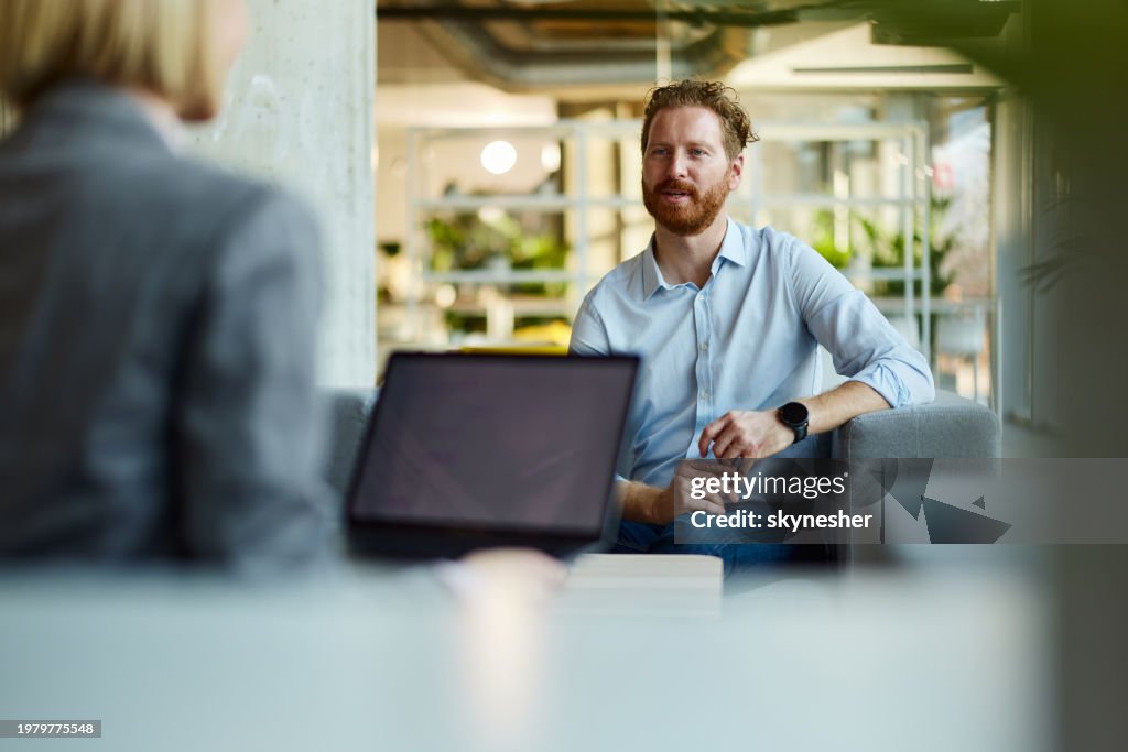 Redhead businessman talking to his colleague at casual office.