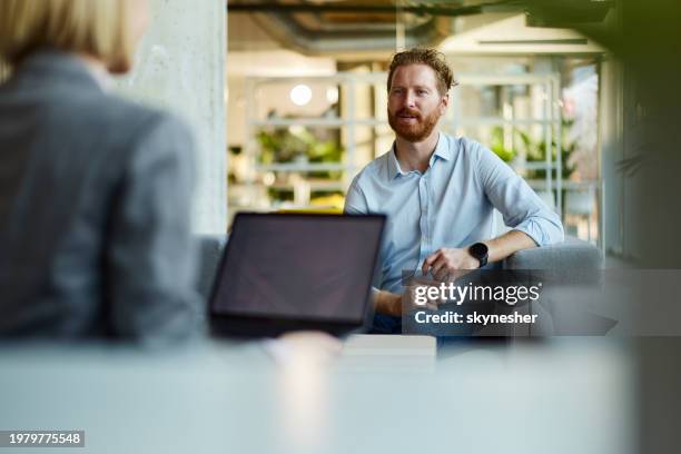 redhead businessman talking to his colleague at casual office. - büro stock pictures, royalty-free photos & images