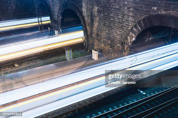 light trails of trains in railroad tunnels - elektrischer zug stock-fotos und bilder