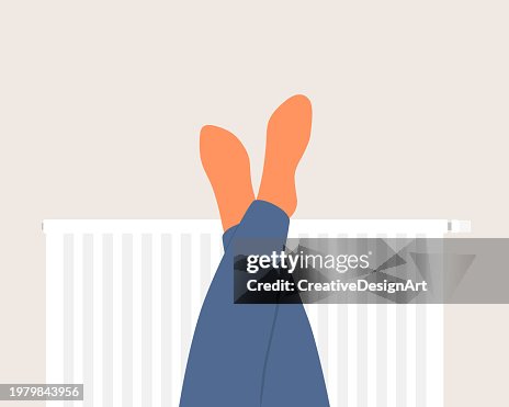 Human Feet In Orange Socks Warming Up On Radiator Human Feet In Orange Socks Warming Up On Radiator