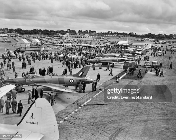 Visitors walk among the aircraft on show, with the Supermarine Swift, a British single-seat jet fighter, in the foreground at the Farnborough...