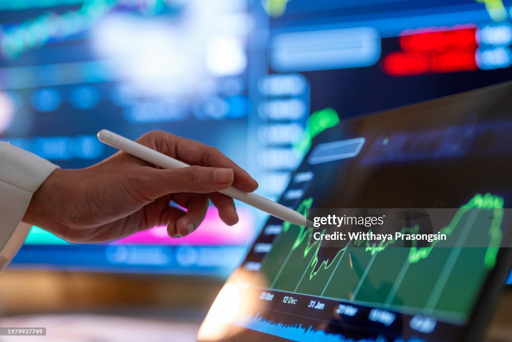 Woman looking stock market Data on Tablet